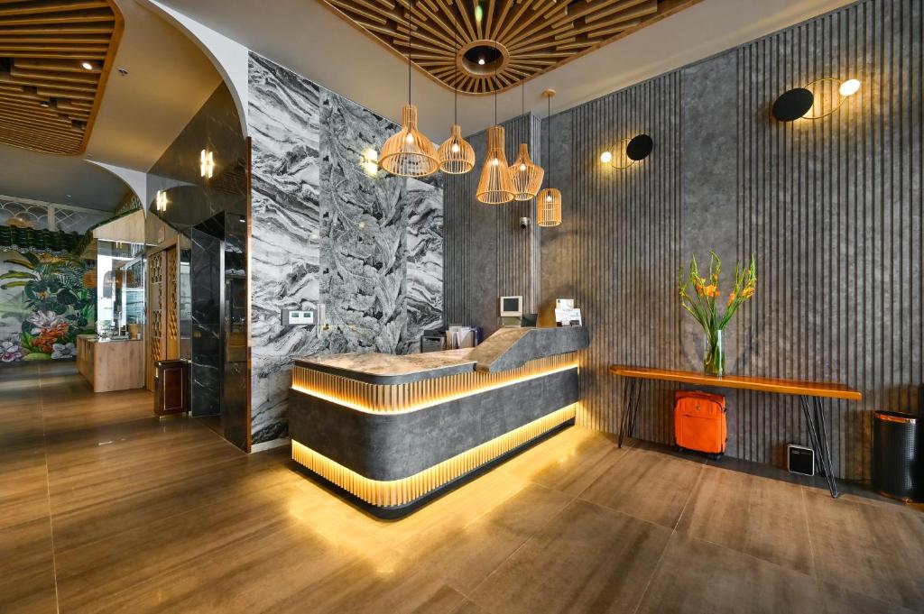 um átrio com um bar com um vaso de flores em La Opera Saigon Hotel em Cidade de Ho Chi Minh