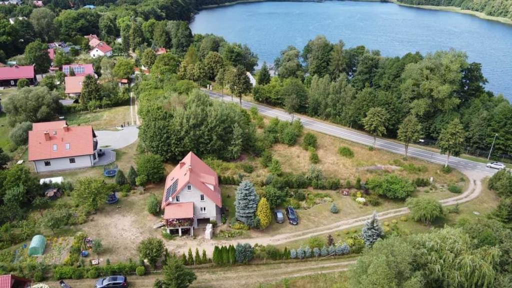 an aerial view of a house on an island next to a lake at Pokoje u Izy Stare Kiejkuty in Szczytno