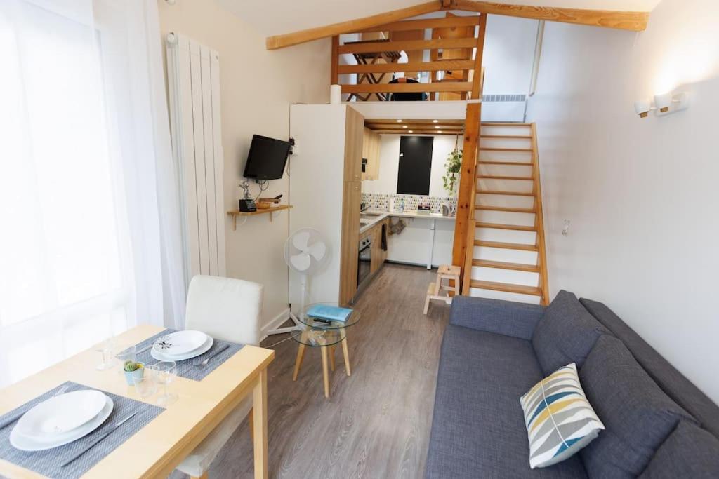 sala de estar con sofá, mesa y escalera en L'appart Cosy -Proche Disney en Mareuil-lès-Meaux