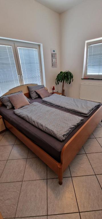 uma cama grande num quarto com duas janelas em Apartman MURKO P-1 