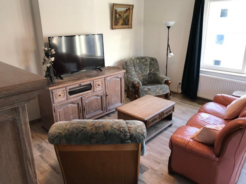 sala de estar con TV de pantalla plana y muebles en RUyi, en De Panne