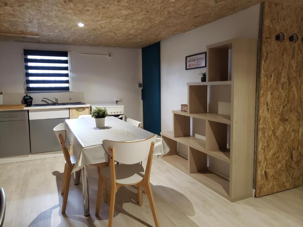 een keuken met een tafel en stoelen in een kamer bij Studio confort chez Lolita et Wilfried in Saint-Laurent-sur-Sèvre