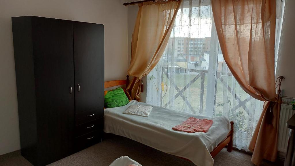 a bedroom with a bed and a large window at Gyvenamųjų patalpų nuoma in Kelmė