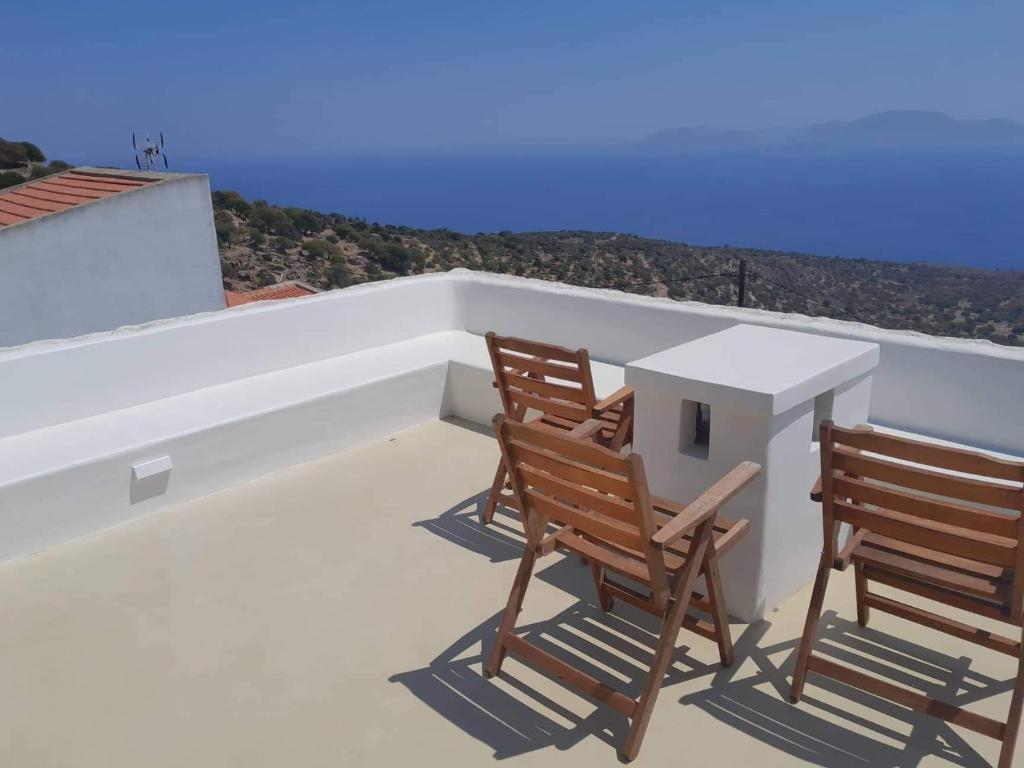 2 Stühle und ein Tisch auf dem Balkon in der Unterkunft Oniropagida Nisyros apartments #2 Nikia view in Nikiá