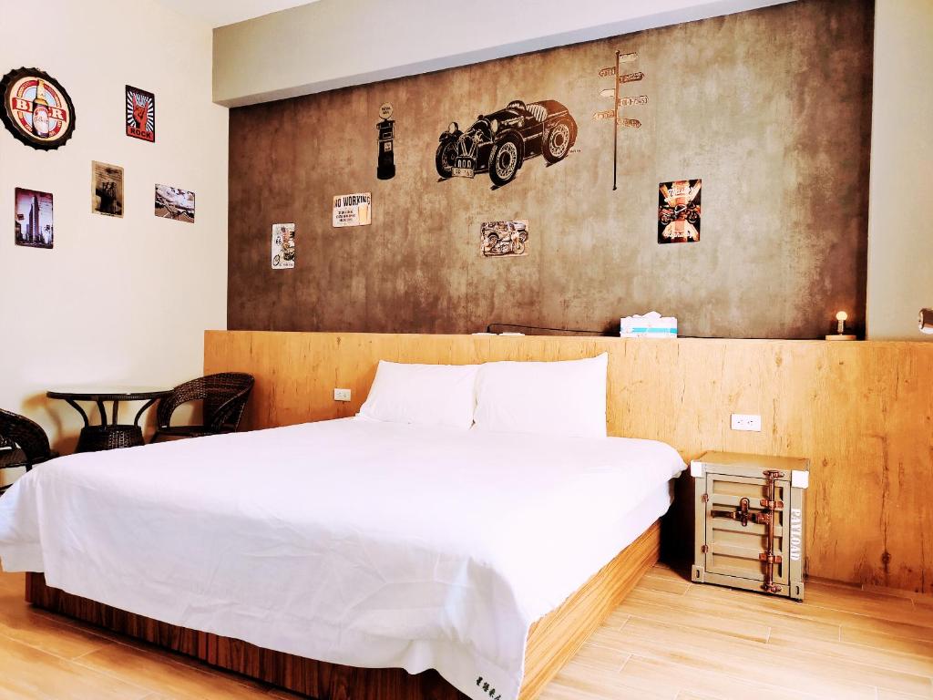 馬公市的住宿－星語采居民宿，一间卧室设有一张大床,墙上有一堵汽车