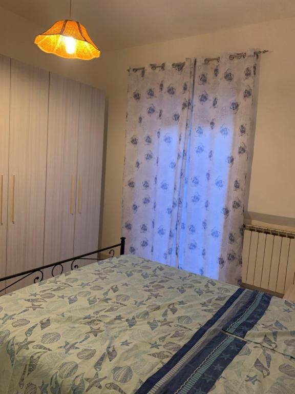 um quarto com uma cama e uma cortina em Rosso Tramonto luxury-blu- LADISPOLI, Lungomare Regina Elena 2 em Ladispoli