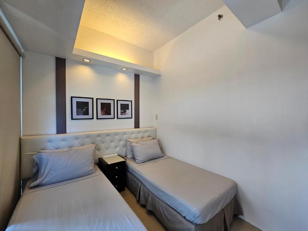 duas camas num pequeno quarto com duas camas em Spacious Studios em Manila