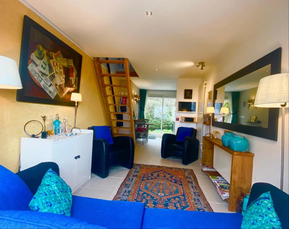 uma sala de estar com um sofá azul e algumas cadeiras em Maisonnette la Grue - Vallée de la Dordogne em Aubazines