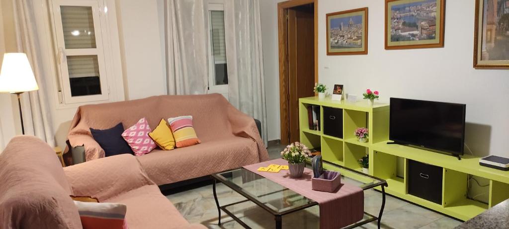 a living room with a couch and a television at PUERTA DEL SOL in Rincón de la Victoria