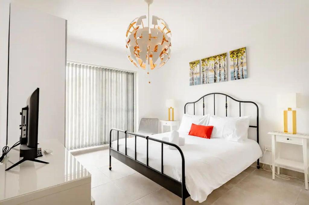 1 dormitorio con 1 cama, TV y lámpara de araña en Casa Leon Malta, en San Julián