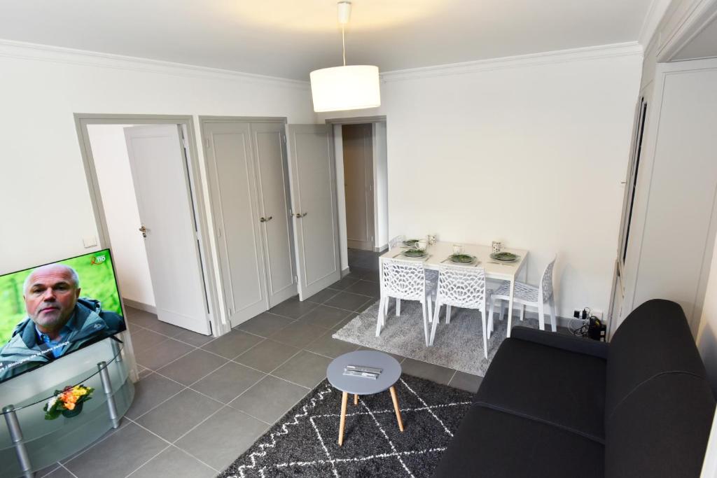 sala de estar con TV y mesa en CONFORTABLE T2 AVEC PARKING PRIVE AU CENTRE de BRIVE en Brive-la-Gaillarde