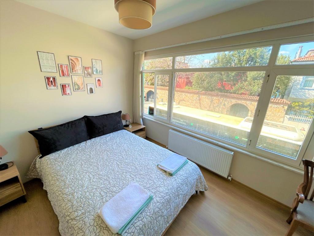 ein Schlafzimmer mit einem Bett und einem großen Fenster in der Unterkunft Kuzguncuk View in Istanbul