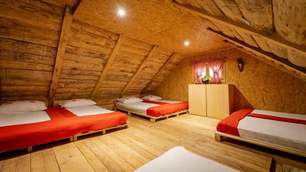 a room with two beds in a log cabin at Robinzonski smještaj "Lazac Lokvarski" Lokve in Lokve
