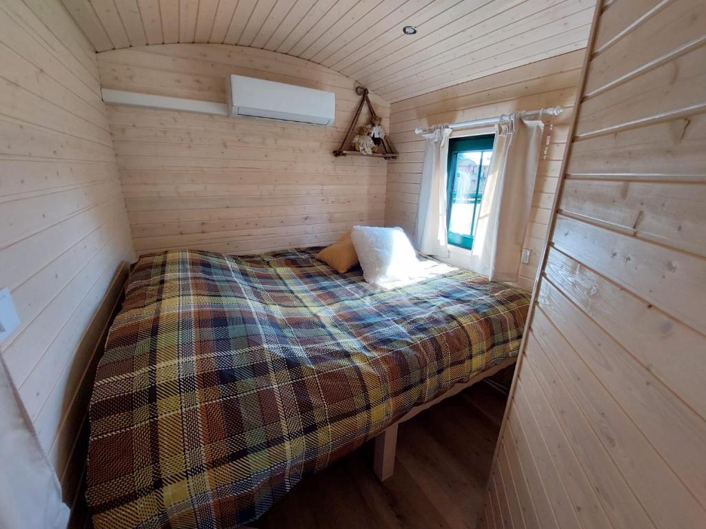 a bed in a small room in a tiny house at Pia B&B Babbita in Hasselt