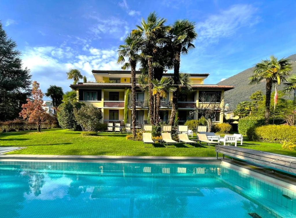 uma casa com piscina em frente a uma casa em Garni Villa Siesta Park em Losone
