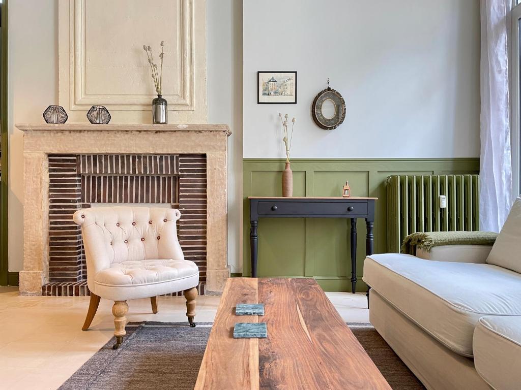 uma sala de estar com um sofá e uma mesa em Le Petit Malo em Bayeux