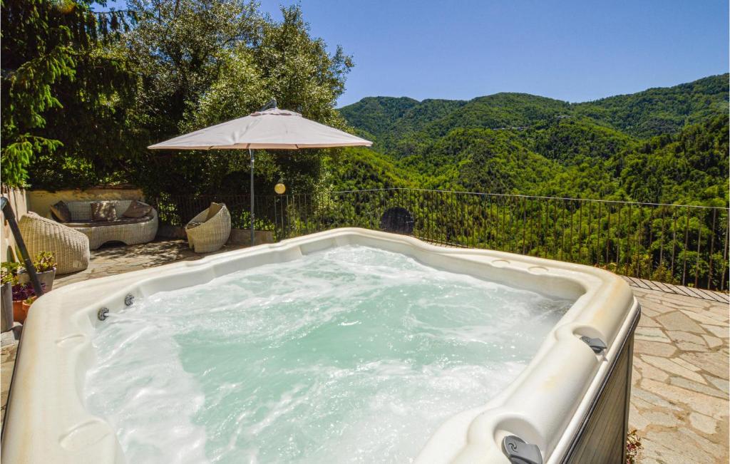 bañera de hidromasaje con sombrilla en el patio en Beautiful Apartment In Carcheto Brustico With House A Panoramic View, en Carcheto