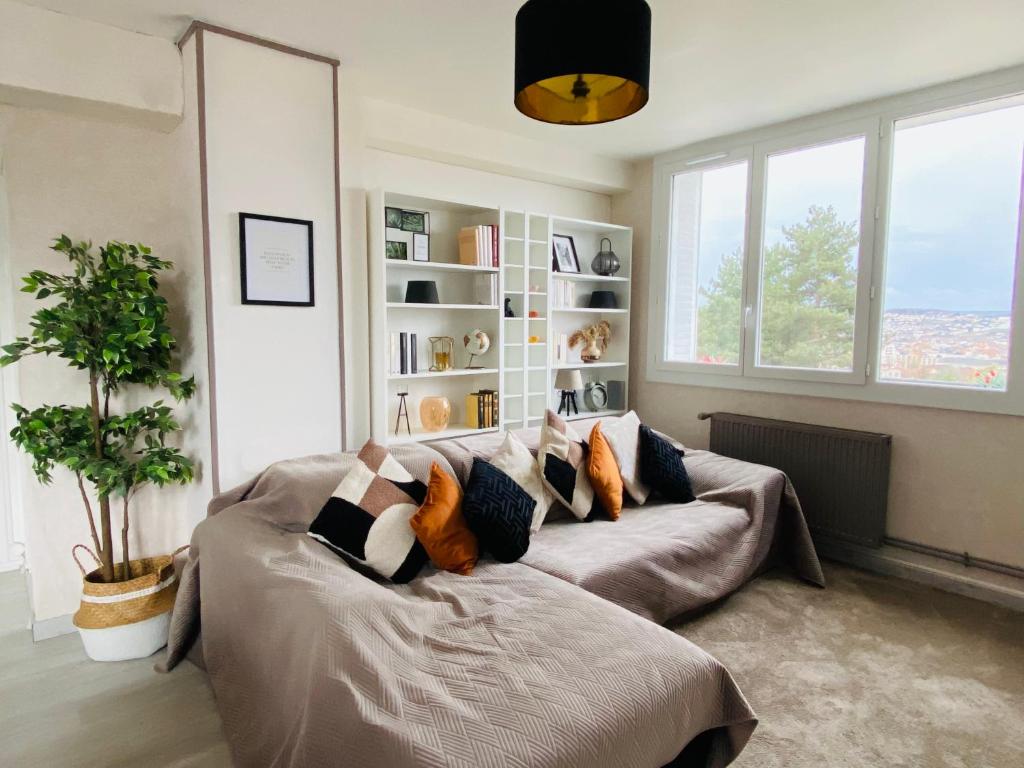 - un salon avec un canapé et des oreillers dans l'établissement Superbe appartement centre Montluçon, proche hôpital, à Montluçon