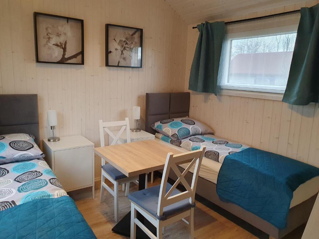 a room with two beds and a table and chairs at Pokoje Babie Lato in Wrocław