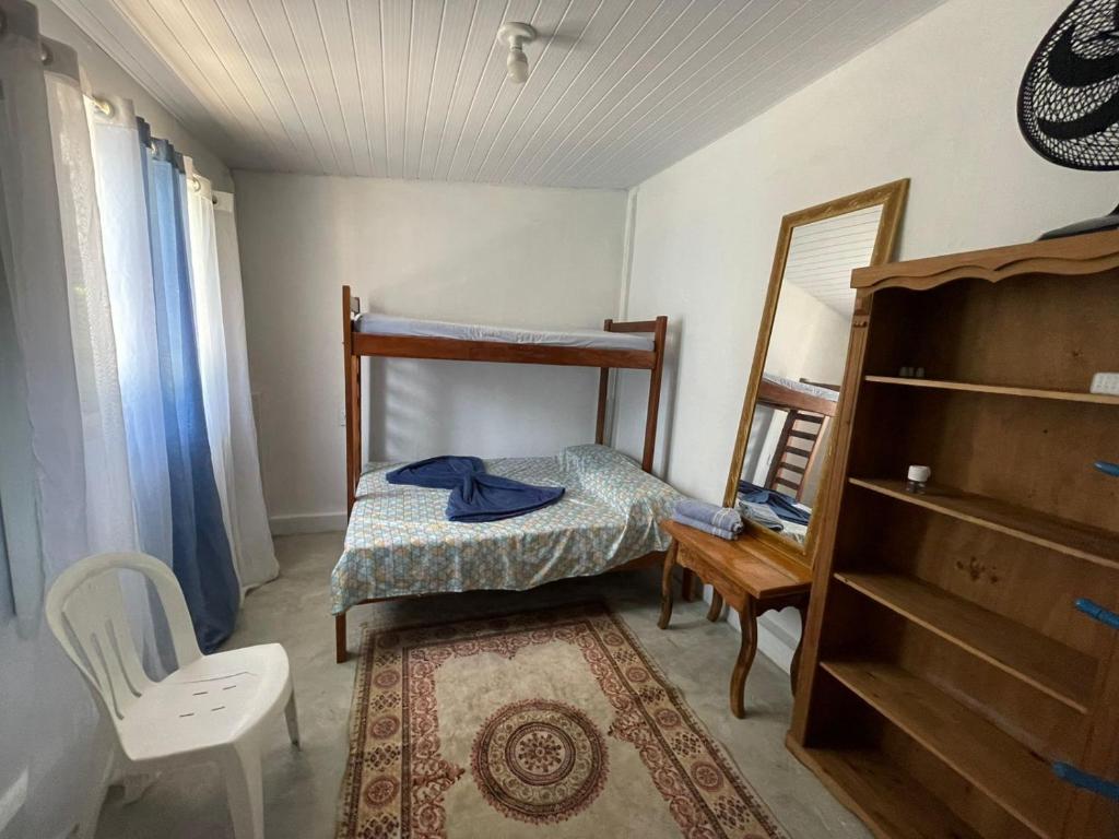 a small bedroom with a bunk bed and a mirror at Pousada do Ade in Ilha do Mel