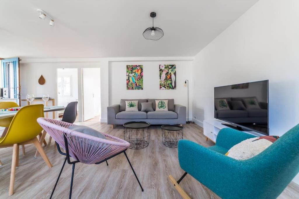 uma sala de estar com cadeiras azuis e amarelas e um sofá em @Villa au coeur de Brive@ avec jardin et garage em Brive-la-Gaillarde