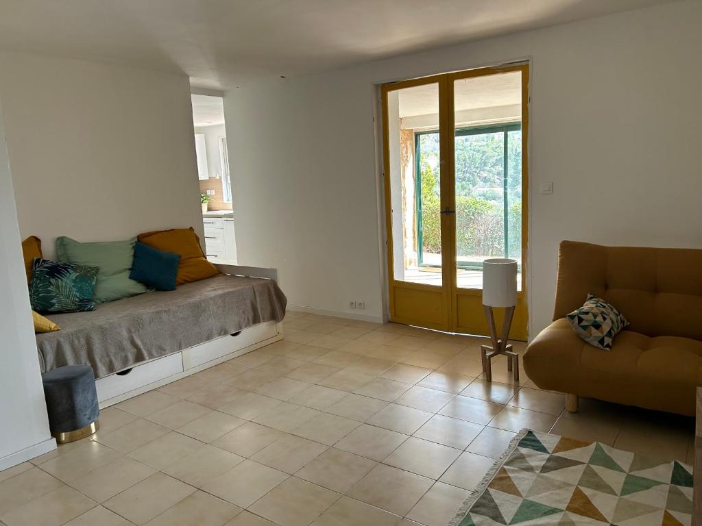uma sala de estar com um sofá e uma janela em Grand T2 bis avec terrasse et vue em Portel-des-Corbières
