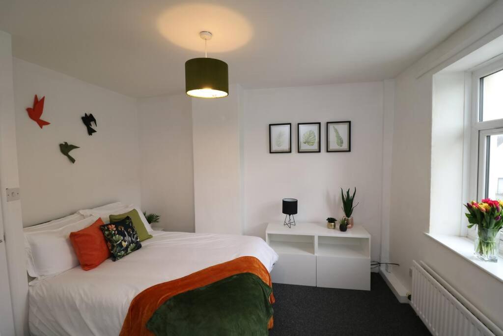 - une chambre blanche avec un lit et une fenêtre dans l'établissement Cosy Two Bedroom Cottage, à Whitehaven