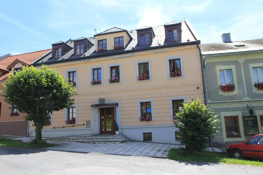 a large yellow building with windows on a street at Apartmany A.Ša Kašperské Hory in Kašperské Hory