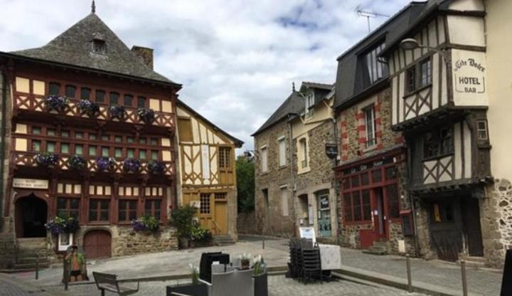 a woman walking down a street next to buildings at Perle rare, appartement paisible et cosy in Lamballe