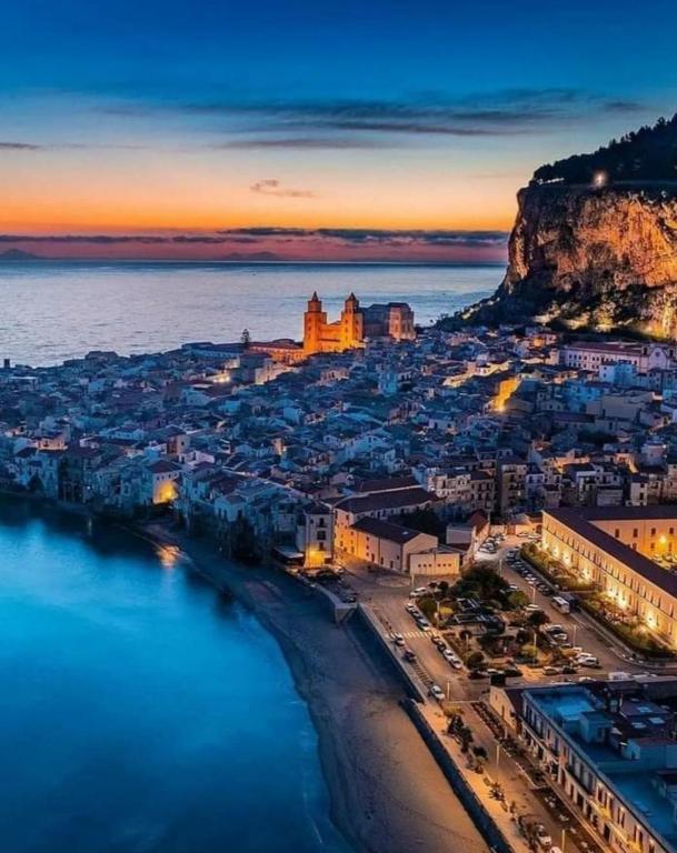 an aerial view of a city with a beach at night at Bellavista63 in Cefalù