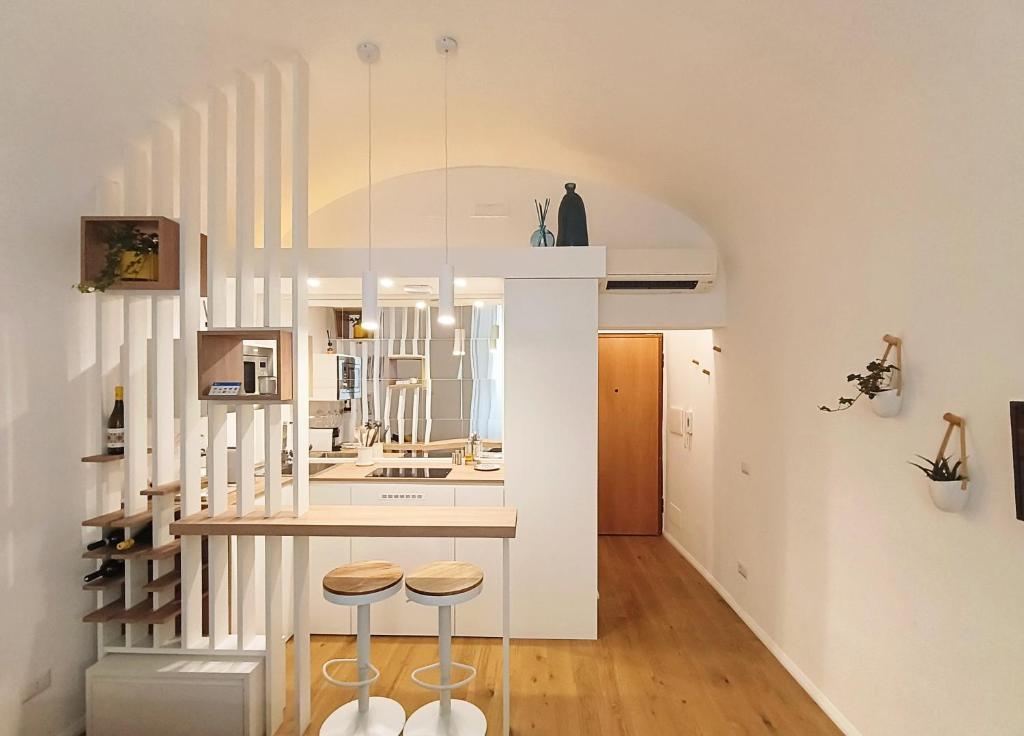 a kitchen with white walls and stools in a room at IN URBS in Salerno