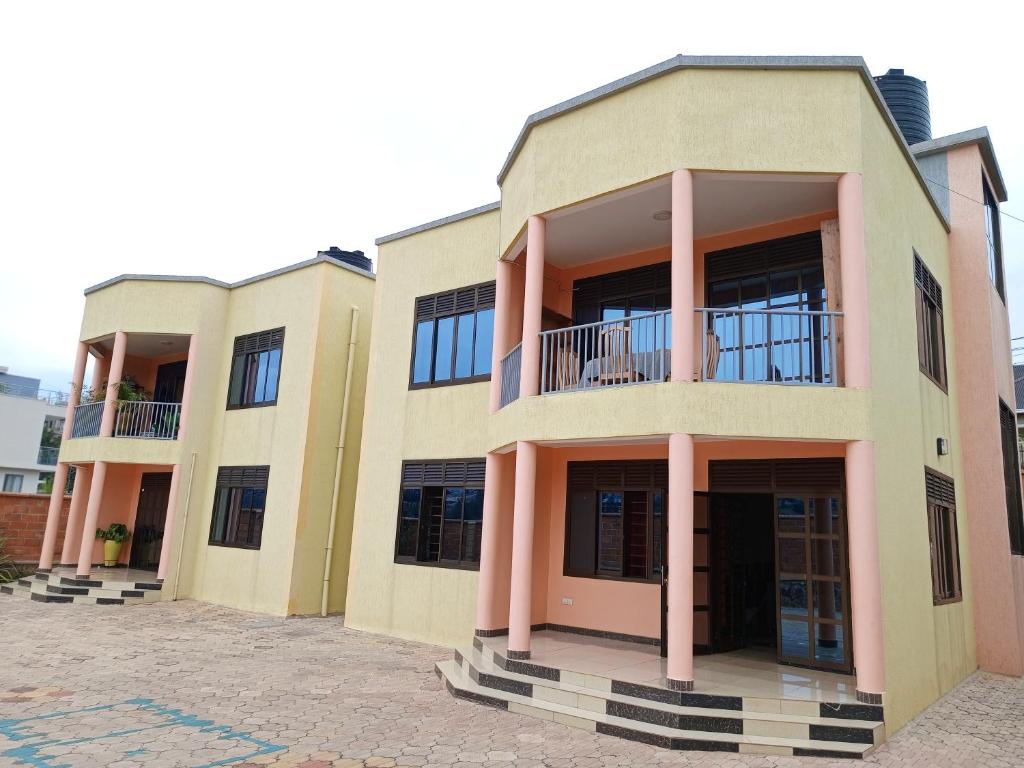 ein großes Gebäude mit rosa Säulen und Fenstern in der Unterkunft JM Apartment in Kigali