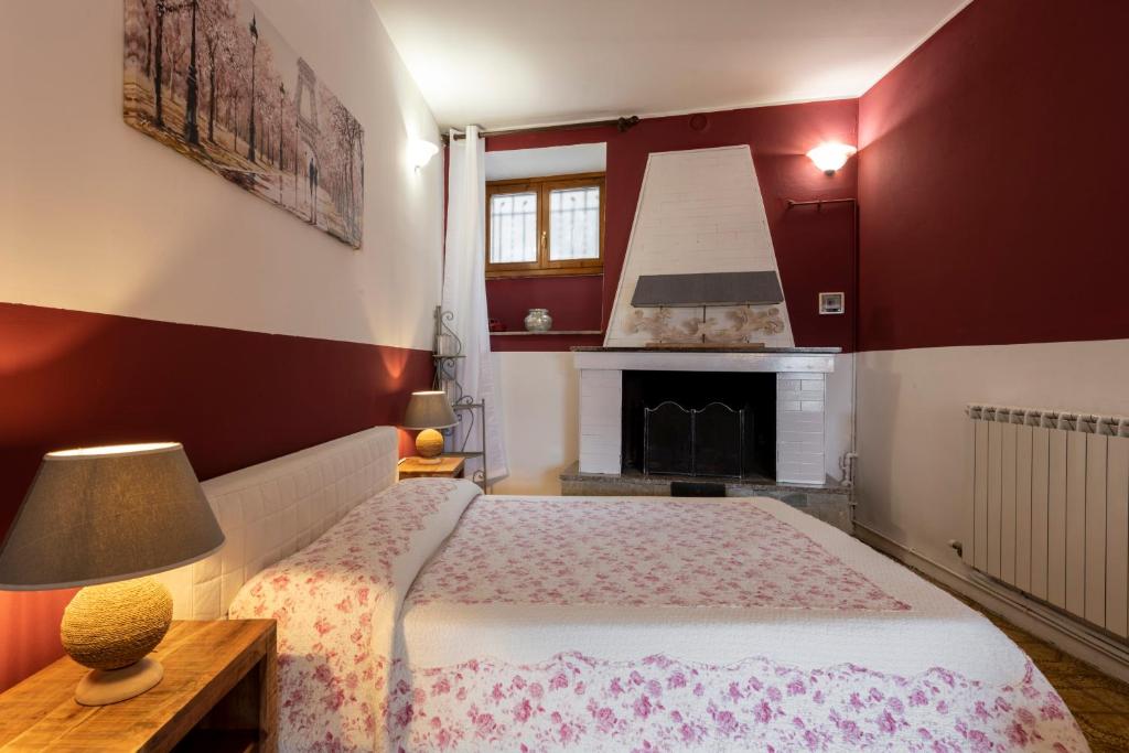 a red and white bedroom with a bed and a fireplace at Charm amidst Lakes & Mountains in Ramponio