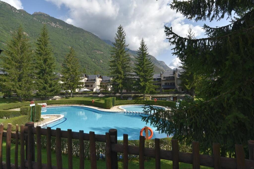 a swimming pool in a yard with a fence at Acogedor apartamento de montaña con jardín y piscina - VU-HUESCA-23-182 in Benasque