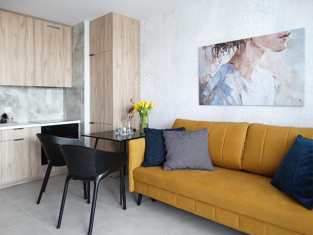 - un salon avec un canapé jaune et une table dans l'établissement Apartament Kraszewskiego, à Białystok