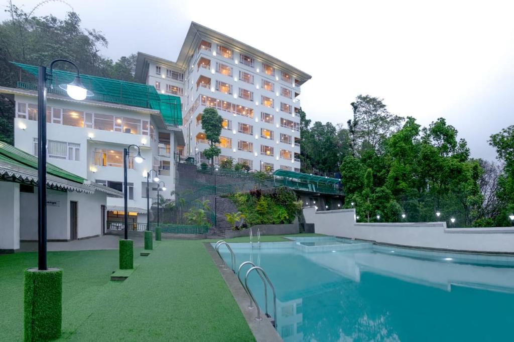 a hotel with a swimming pool in front of a building at Treenz Hotel in Gangtok