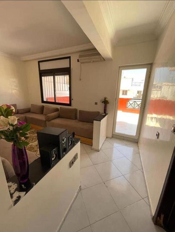 a living room with a couch and a table at Appartement in Oulad Yakoub