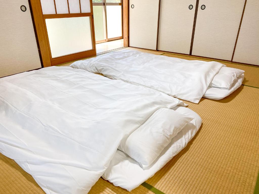 Postel nebo postele na pokoji v ubytování よらんかな〜海と山と暮らす、見晴らしの一棟貸し宿〜