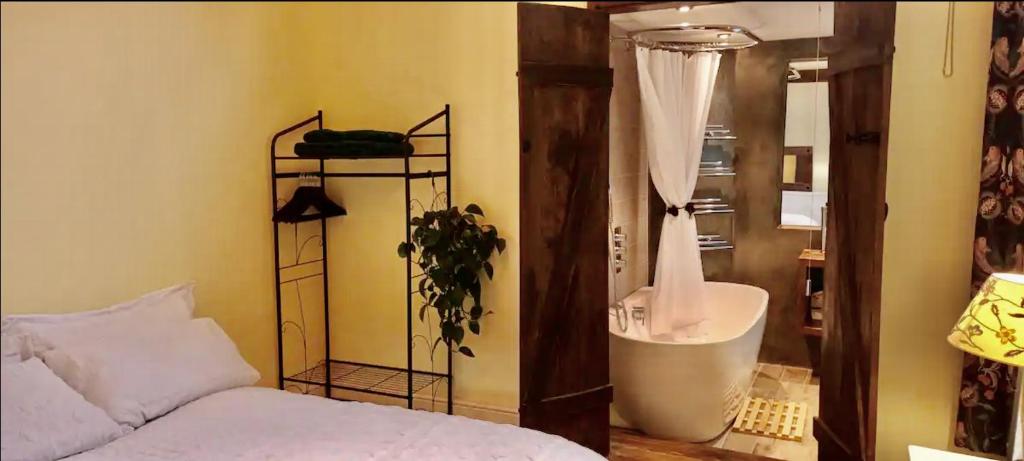 1 dormitorio con 1 cama y ducha. en Room with luxury private bathroom, independent entrance, near Tube en Londres