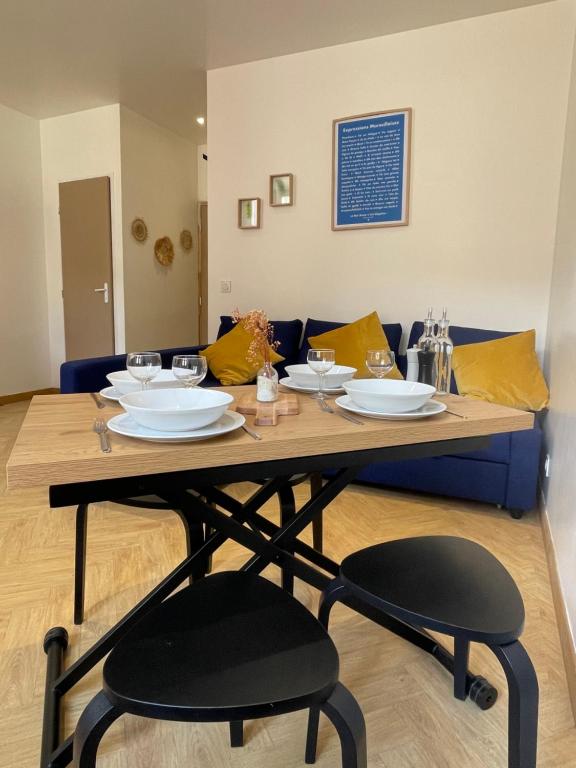 une table en bois avec deux chaises et un canapé bleu dans l'établissement APPART Le BER'AMAR L'ESTAQUE, à Marseille