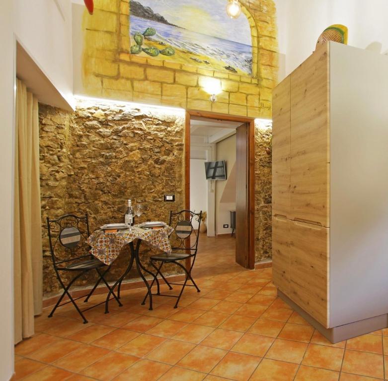 uma sala de jantar com mesa e cadeiras e uma parede de pedra em Antica Cefalu' em Cefalù