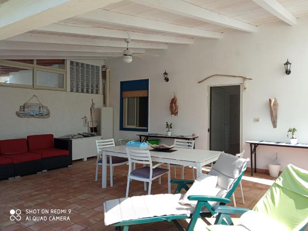 a kitchen and a living room with a table and chairs at Villa Amenta in Fontane Bianche