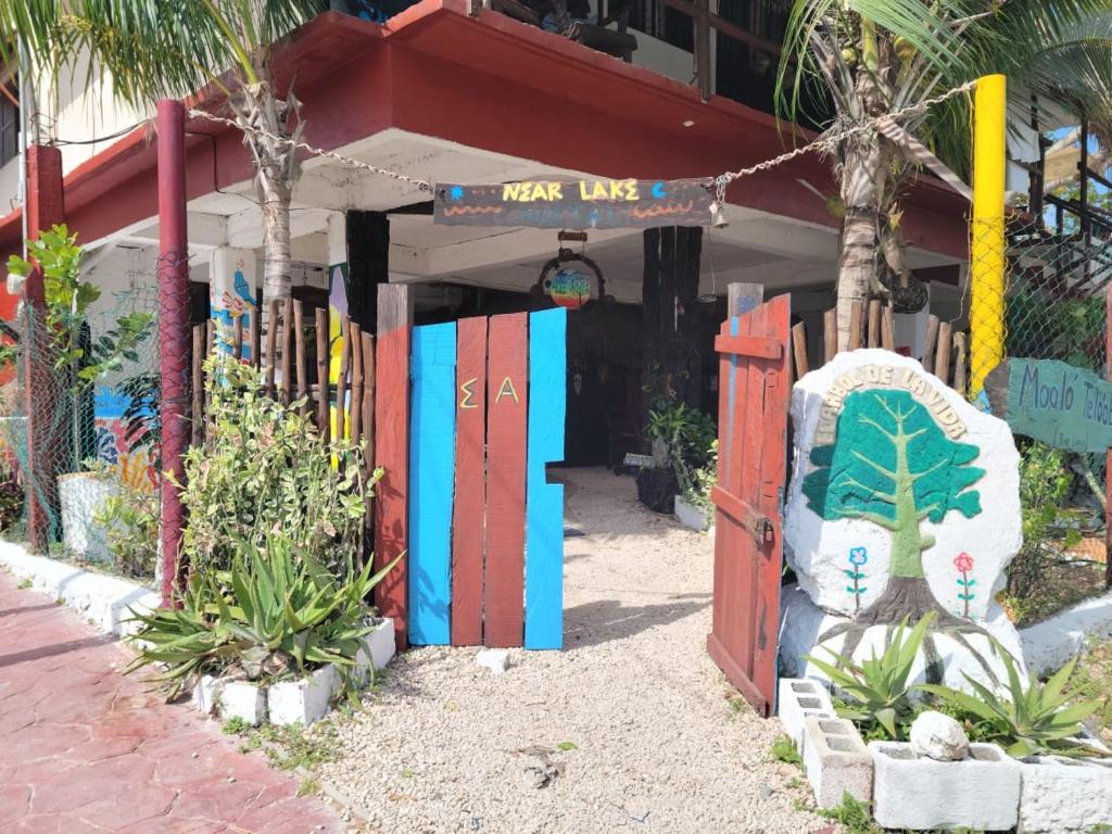 a building with colorful doors and plants in front of it at Near Lake Hostal in Bacalar
