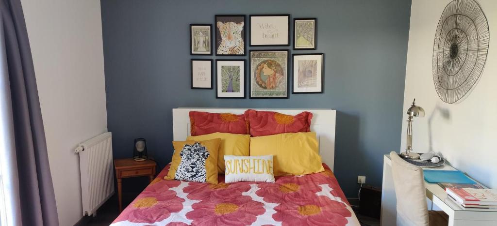 een slaapkamer met een bed met gele en rode kussens bij Ocalm in Longjumeau
