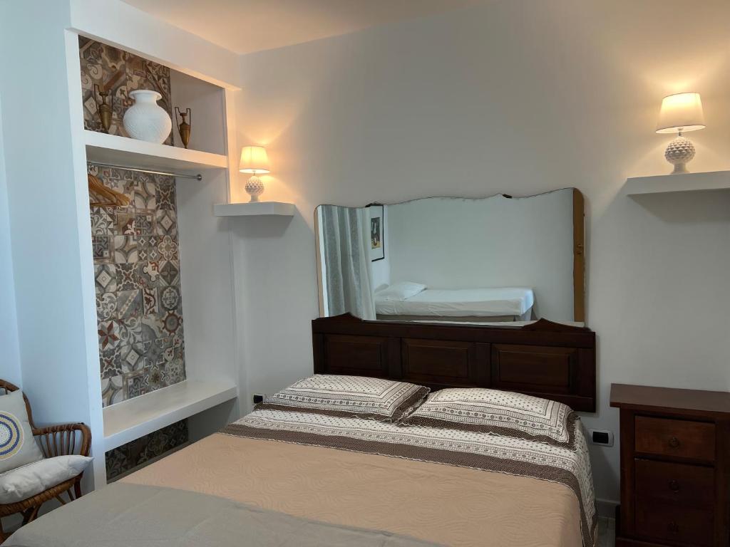 een kleine slaapkamer met een bed en een spiegel bij Attico Gallipoli in Gallipoli
