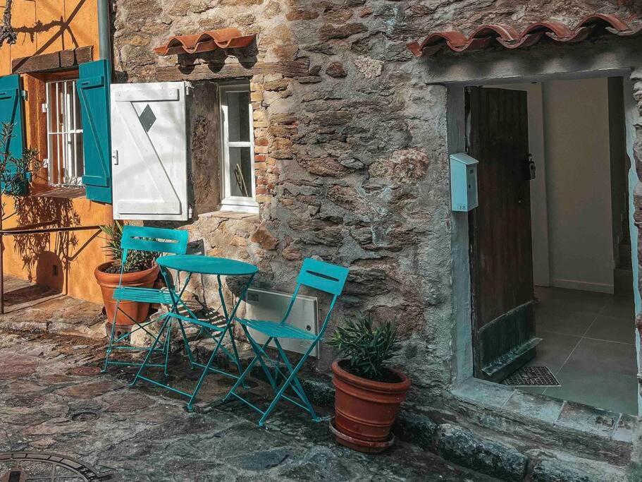 um grupo de cadeiras e uma mesa fora de um edifício em Maisonnette 2 pièces en Provence em La Garde-Freinet