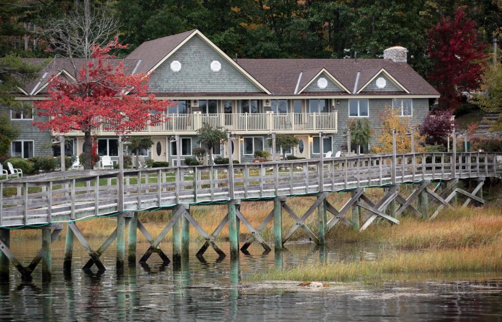 a large house on a bridge over the water at Riverside with balcony Sheepscot Harbour Vacation Club Studio #215 in Edgecomb