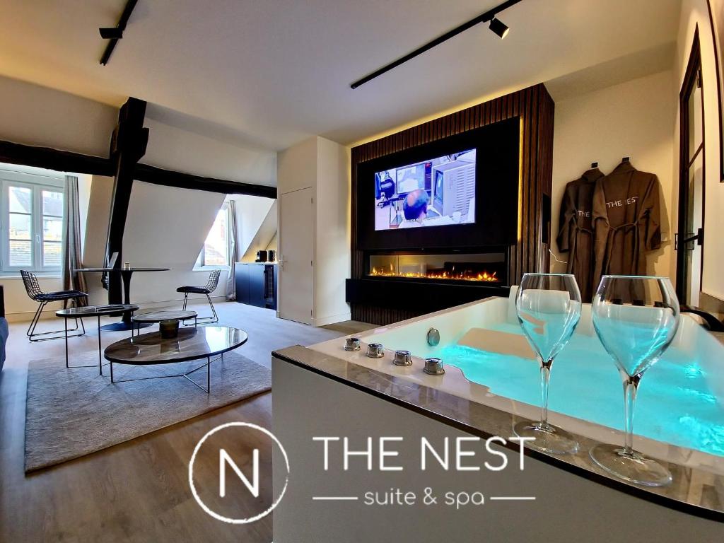 een woonkamer met een bad en 2 wijnglazen bij The Nest. duplex jacuzzi hyper centre de Senlis in Senlis