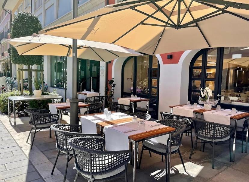 ein Restaurant mit Tischen, Stühlen und Sonnenschirmen in der Unterkunft Ca’ Bruno Masaneta in Grado