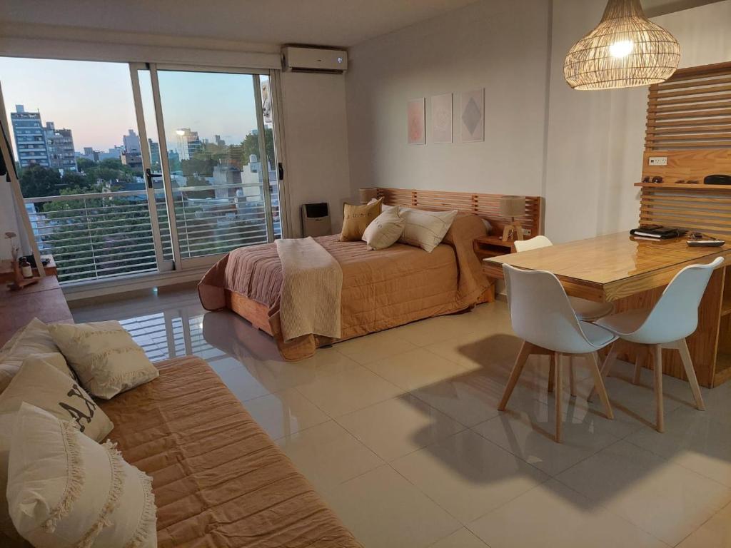 ein Schlafzimmer mit einem Bett und einem Tisch sowie ein Esszimmer in der Unterkunft Apartamento Hygge 42 in La Plata